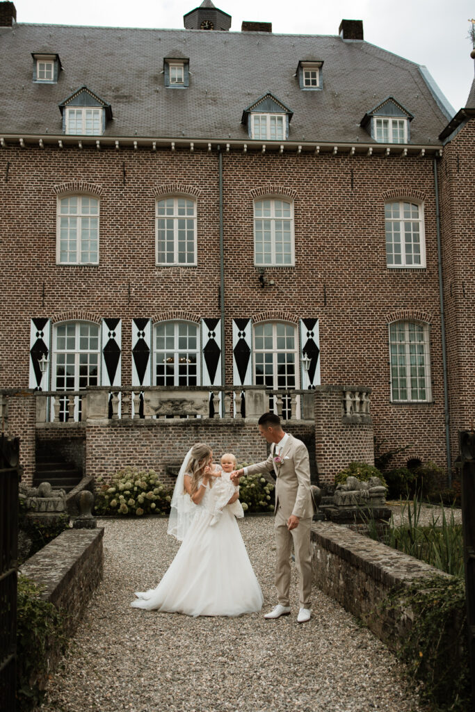Ceremonie op de binnenplaats van Kasteel Aldenghoor met houten stoelen en bloemendecoratie