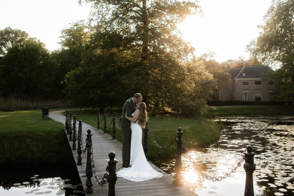 Intieme close-up kus bruidspaar met wit en zalm bruidsboeket, romantische trouwfotografie Kasteel Ruurlo