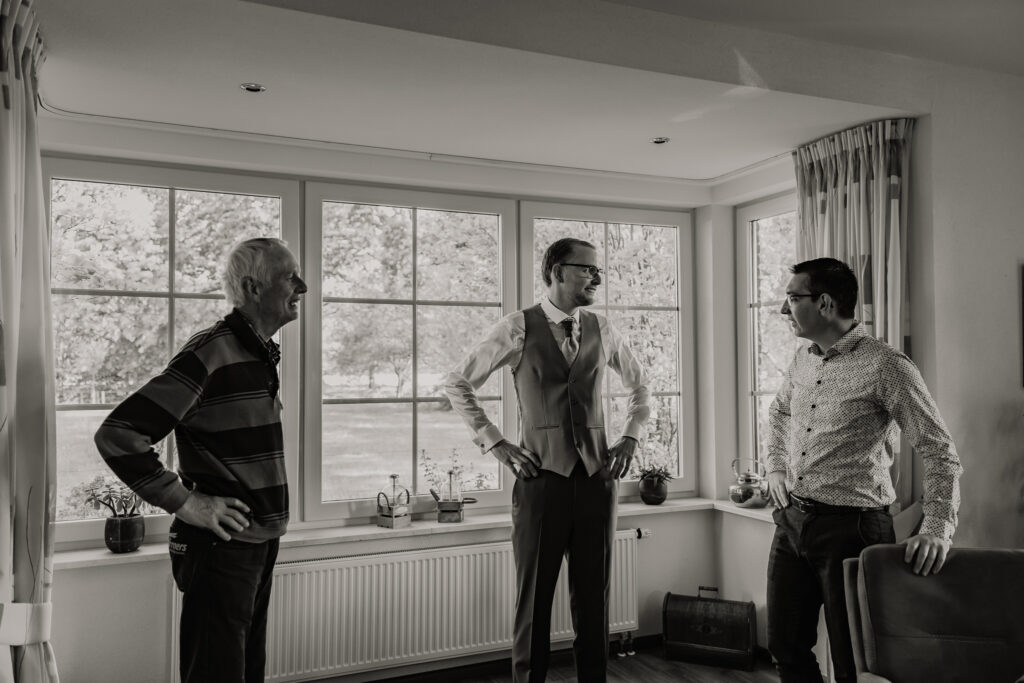Bruidegom in groen driedelig pak bij raam during getting ready, trouwfotografie Kasteel Ruurlo Achterhoek